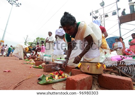 ATTUKAL, INDIA - MAR 7: A woman devotee takes part in the Attukal Pongala festival where a ritual of boiled rice in earthern pots is offered to the goddess on March 7, 2012 in Attukal,Trivandrum India.