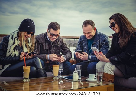 Group of people looking at a cell phone and laughing