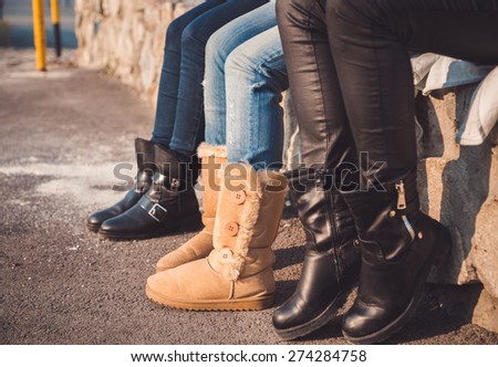 Three pairs of girls legs with boots on them