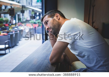 Man thinking by the bar window