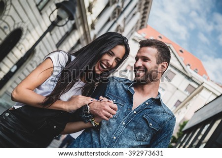 Couple laughing and holding hands in the city