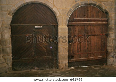 Two heavy brown doors in a dark French church