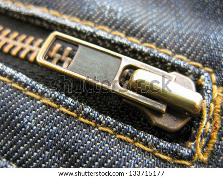 Close up of a zip on a pair of blue jeans half unzipped
