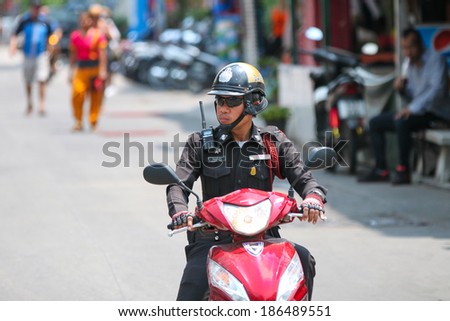 BANGKOK - MARCH 27: Unknown Thai police man on a motorbike on the streets of  March 27, 2014 in Bangkok. Thailand. Traffic laws are often ignored and unenforced