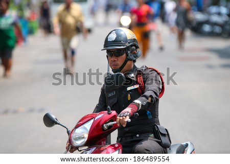 BANGKOK - MARCH 27: Unknown Thai police man on a motorbike on the streets of  March 27, 2014 in Bangkok. Thailand. Traffic laws are often ignored and unenforced
