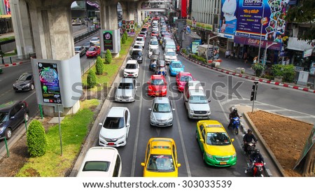 BANGKOK - JANUARY 13 : Traffic approaching a dead end on a busy street in the city, on 13 January 2015 in Bangkok, Thailand. Center city with two levels skytrain tracks above street.