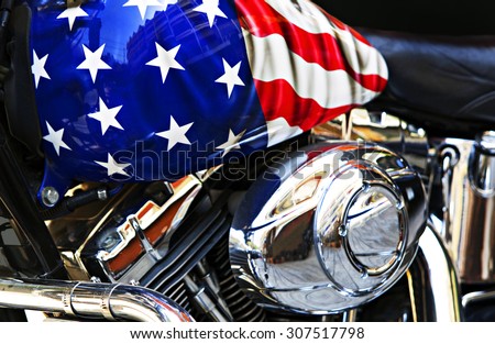 Close up motor and the fuel tank of a motorcycle with an American flag