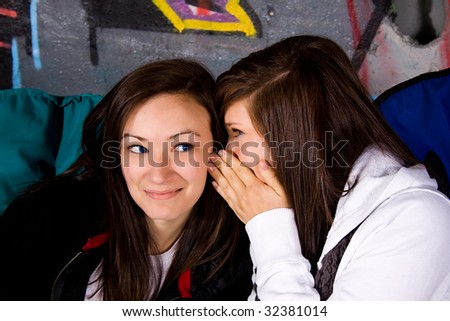 One Teenage Whisper Something into the Ear of her Friend