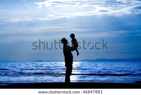 Father throwing his kid up in the air on the beach