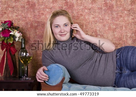 Beautiful Woman Relaxing byLaying on the Couch and Drinking Wine