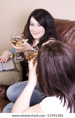 Two Girls at Home Sitting on the Couch with a Laptop and Wine