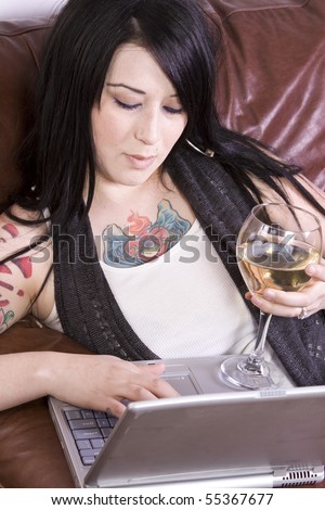 Woman Relaxing on the Couch with a Glass of Wine and Laptop
