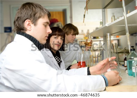 graduate - chemists in the lab with a teacher conducting experience with chemical reagents