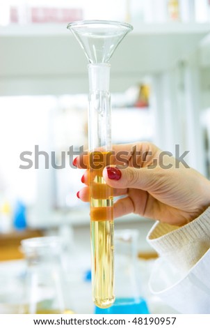 beautiful woman\'s hands holding a test tube with reagent in chemical laboratories
