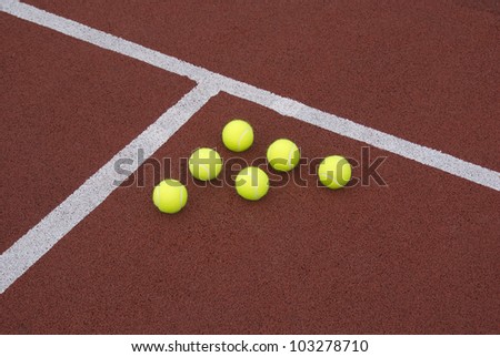 Six yellow tennis balls on court as triangle figure