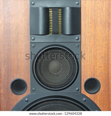 Loud speaker system with wood finish and metal black grills details closeup