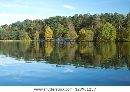 Early autumn landscape with Forest and trees reflected in water