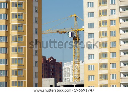 Hoisting tower crane in construction new apartment building process inside residential district