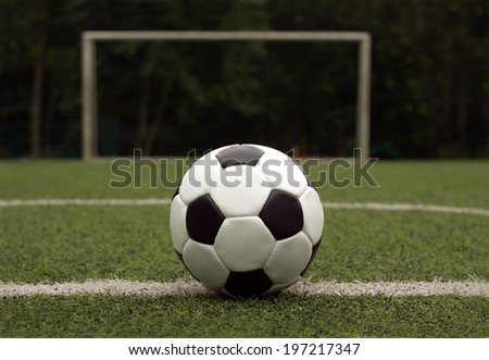 White and black ball for playing soccer  on synthetic grass  against gate on sport field close-up