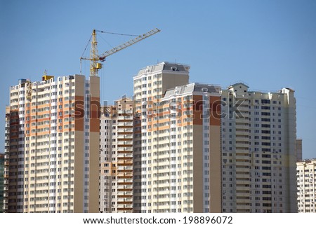 Many new high-rise buildings constructing in process over clear blue cloudless sky horizontal view