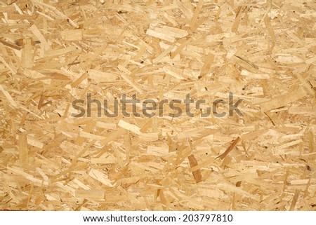 Oriented Strand Board. Building material. Wooden panel made of pressed sandy brown wood shavings as background closeup