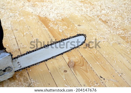 Chainsaw for cutting wood or other materials with a long, thin serrated steel blade close up before sawdust and shavings