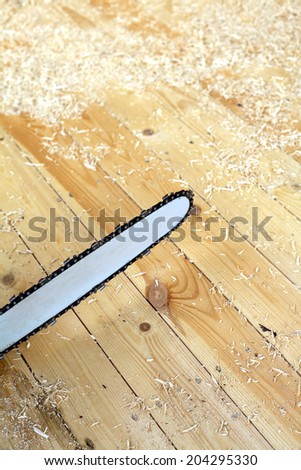 Chainsaw for cutting wood or other materials with a long, thin serrated steel blade close up before sawdust and shavings
