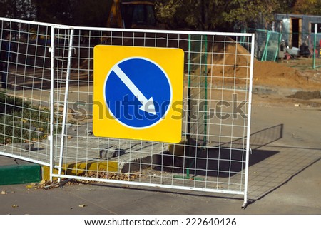 Repair work. Road sign indicating detour hanging on the fence. Photo Close-up