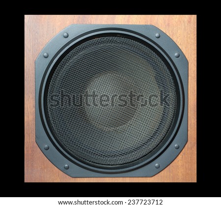 Subwoofer Loud speaker system with round black grill and wooden finish isolated on black closeup