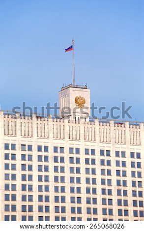 Top of White house. Russian house of parliament in Moscow with flag and coat of arms close up