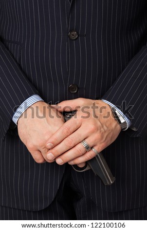 The man in a suit aims from a pistol