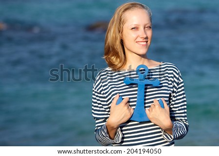 The young beautiful girl on a beach with an anchor