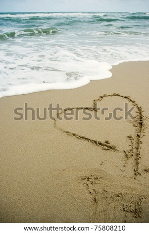 heart drawing on the sand beach