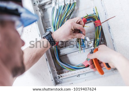 Electrical System Installation by Professional Caucasian Electrician. Construction and Power Industry Theme.