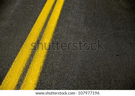 Road Pavement Backdrop - Black Road Pavement with Yellow Double Line. Travel and Transportation Background Theme.