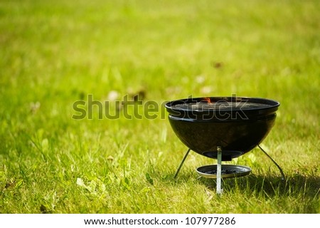 Small Barbecue Grill on Green Summer Grass. Outdoor Fun and Cook. Recreation Photo Collection