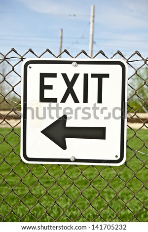 Exit Sign on the Fence. Black Arrow Showing the Right Way to Exit. Signage Photo Collection.