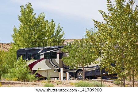 Class A Diesel Pusher RV ( Motorhome ) - Recreational Vehicle Between Trees in One of Arizona RV Parks. Traveling Photo Collection.