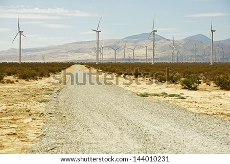 Rough Desert Road. gravel Road in Mojave Desert California. Wind Turbines Ahead. California Photo Collection.