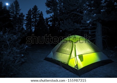 Small Camping Tent Illuminated Inside. Night Hours Campsite. Recreation and Outdoor Photo Collection.