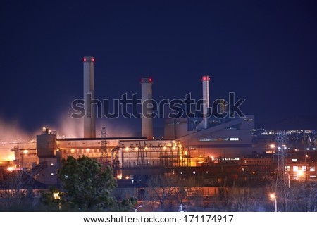 Industrial Zone at Night. Industrial Buildings Illumination and Smoke.