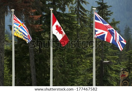Three Canadian Flags. British Columbia, Canada National and British National Flag. Tree Large Flags on Poles.