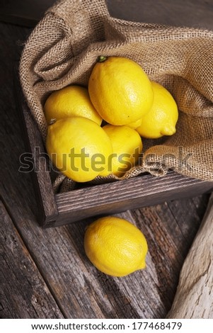 Fresh Raw Lemons Inside Wooden Crate on Aged Wood Table. Lemon Fruits.