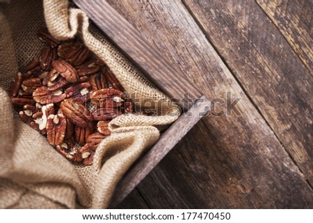 Raw Pecans in Small Wood Crate and Canvas. Top View.