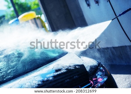 Hand Car Wash Cleaning. Bluish Color Grading. Cleaning Modern Compact Car.
