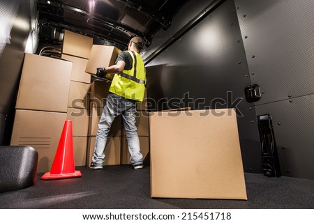 Cargo Van Loading by Worker. Man Carrying Boxes In the Cargo Van For Customer Delivery. Shipment Preparation and Processing.