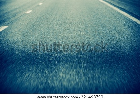 On the Road Background. Road in Motion. Pavement Closeup During Driving.