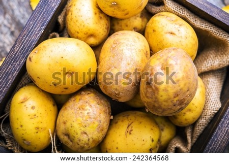Idaho Golden Potatoes. Raw Potatoes in Small Wooden Crate.
