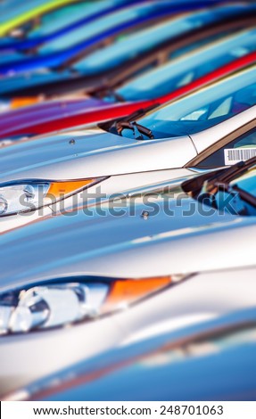 New Cars Stock in Row. Modern Compact Cars Dealership Parking Lot Closeup.