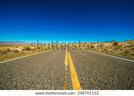 Nevada Backcountry Straight Rural Road. Nevada Highway and Clear Blue Sky.